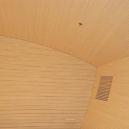 Huoneen nurkka jonka seinät ja katto ovat puupaneelia 